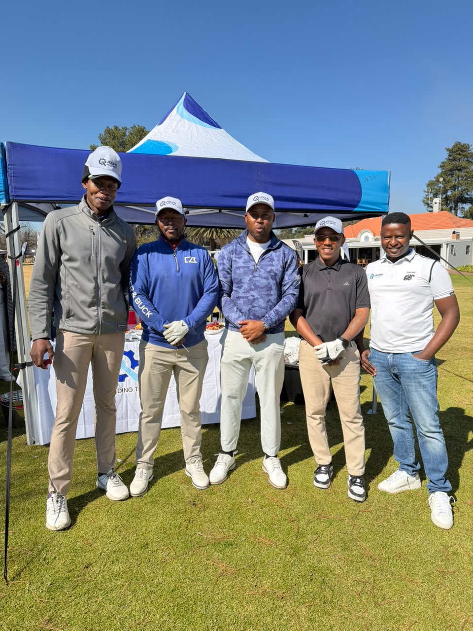 Golf day participants standing at the UDUHU Holdings activation area