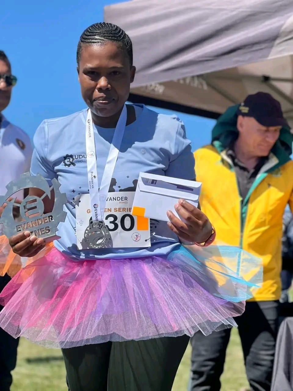 UDUHU Wellness Race participant holding a medal and award after the event