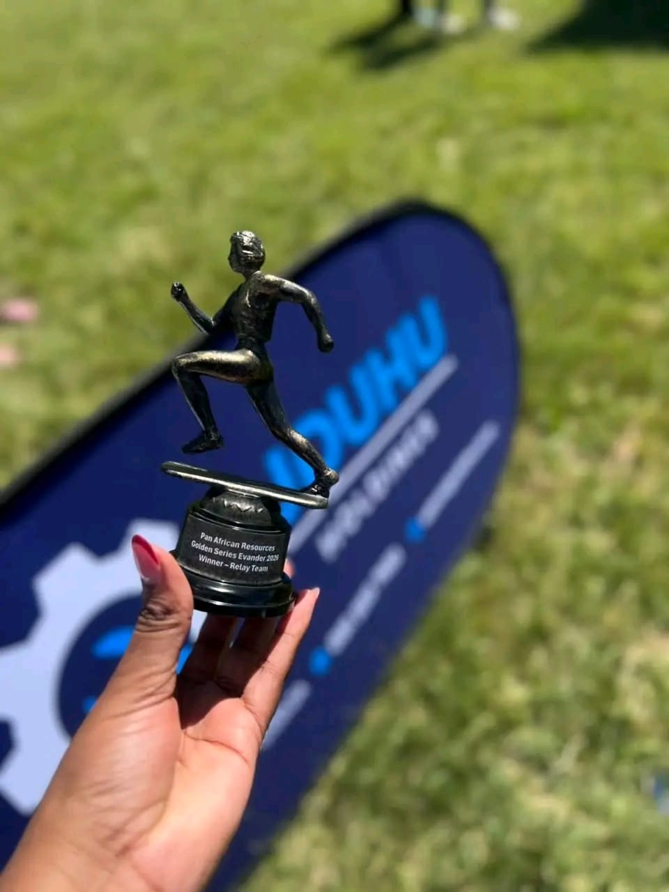Wellness Race trophy photographed in front of UDUHU Holdings branding